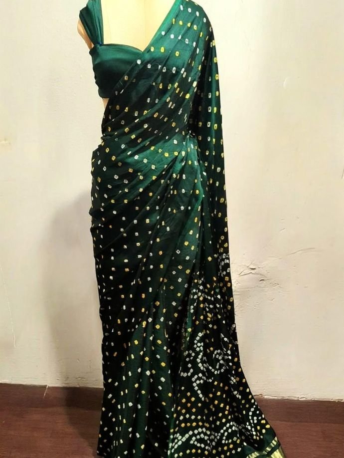 Dark green Bandhani saree with intricate golden woven border and traditional ethnic motifs, elegantly draped for festive and wedding occasions.